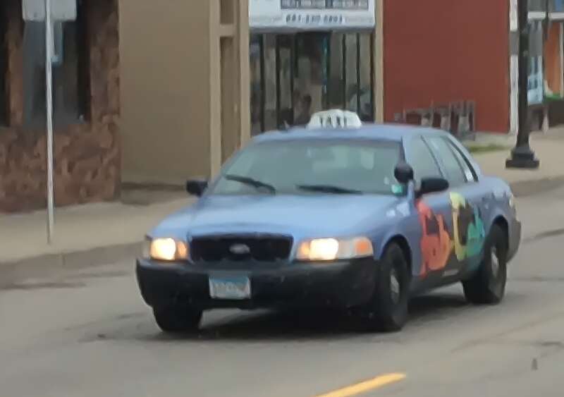 A Ford Crown Victoria taxicab version in service of Rainbow Taxi. This one is the "Fab Cab." Photographed in St. Paul, Minnesota, United States of America.