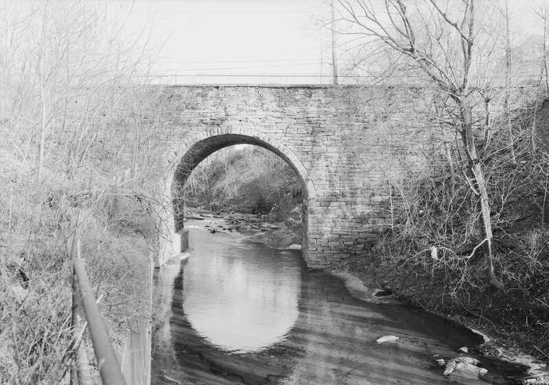 Western (downstream) side of the Bridge in City of Wilkes-Barre, which carries River Street over Mill Creek in Wilkes-Barre, Pennsylvania, United States.  Built in 1885, this single-span stone arch bridge is listed on the National Register of