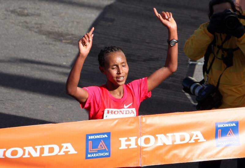 Fatuma Sado of Ethiopia throws her hands in the air as she crosses the finish line at the 2012 Honda LA Marathon.
Fatuma beat her personal best by more than two minutes and won the $100,000 gender challenge bonus.
Photo by <a