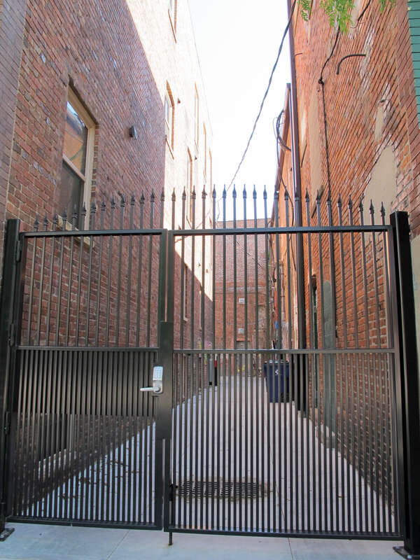 Photo of a gated alley in Lincoln, Nebraska.  This alley is the first east of N. 14th on the south side of "P" Streets.  Photo is taken looking south from the south sidewalk on "P".