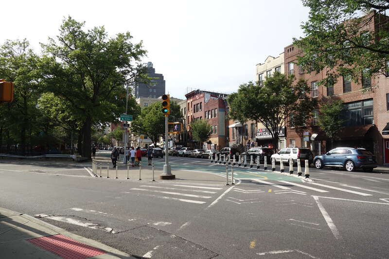 A grade-level pedestrian island and a cycleway in front of LaGuardia Playground, at South 4th Street and Borinquen Place (Grand Street) near Havemeyer Street in Williamsburg, Brooklyn. The cycle lane eventually feeds into the Williamsburg Bridge.
