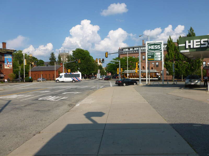Looking souteast along Merrimack Street near the intersection with Dutton Street.  At left is a canal building from 1848; behind that, Saint Anne's Episcopal Church is visible.  At right is a trolley used to transport visitors throughout the Lowell