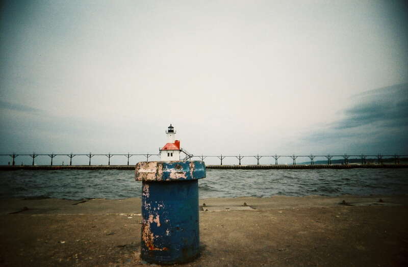 A boring lighthouse, bad lighting, and the family already walking ahead and tired of waiting for me... time to fall back to the old perspective trick... St. Joseph Pier in Michigan with the Vivitar Ultra Wide &amp; Slim. (Explore)