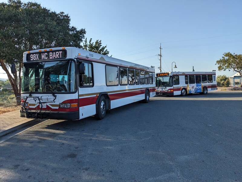 Bus 2332 is running on route 98X while bus 1401 is operating on route 18 in Martinez station. Forty buses in the 2300 series replaced ten hybrids and thirty diesel buses made from 2009-10 in mid-2023.