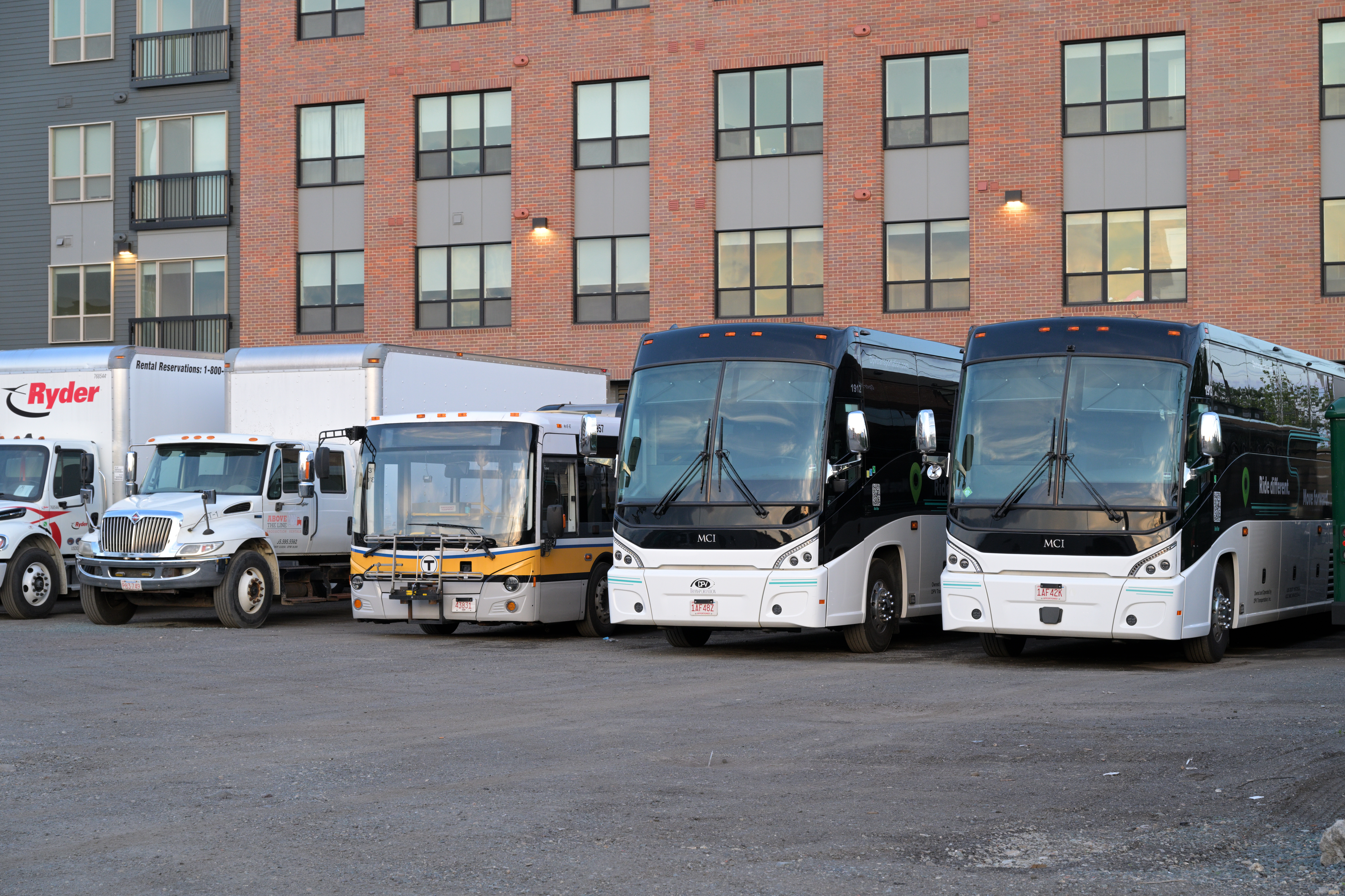 DPV Transportation buses, including a Vicinity Classic in MBTA colors (center) used on route 714/716 service, at DPV Transportation's lot in Everett, Massachusetts