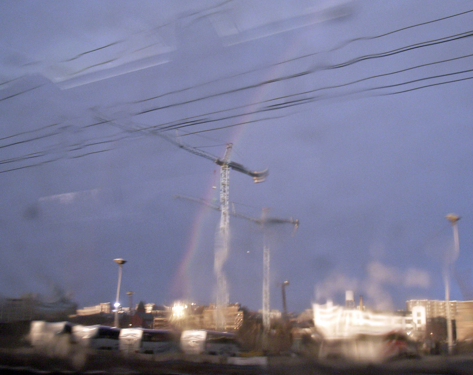 Early on Sunday, a rainbow appears over boomtown Washington. (View from NEC Amtrak entering Union Station, near New York Ave. The plexiglas windows don't shed rain very well.)