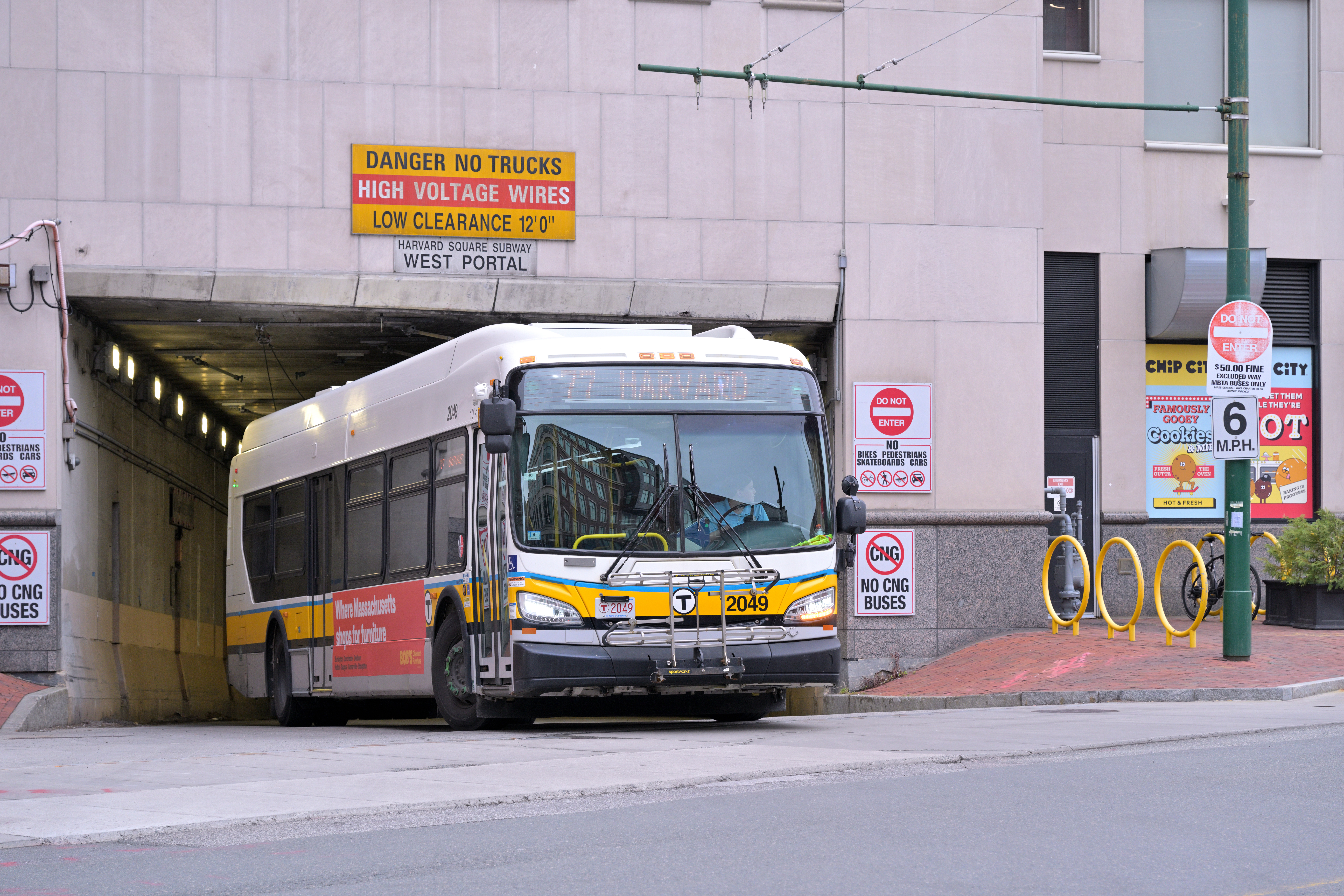 An MBTA route 77 bus exits the west portal of the Harvard Bus Tunnel.