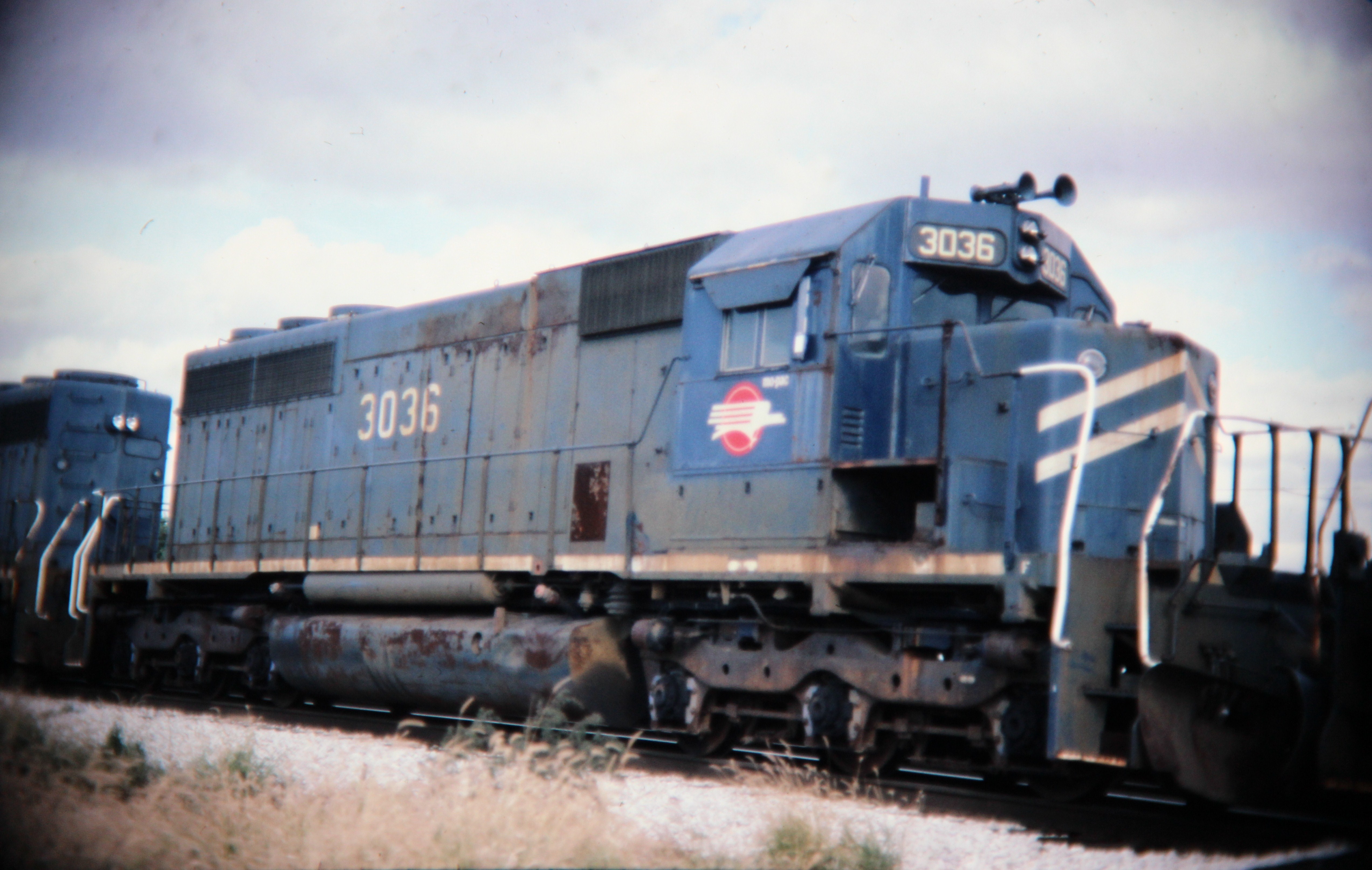 Mopac SD40 dead in tow, Savoy, IL; Western U.S. railroads, 1986; digital copy of slide. Complete indexed photo collection at WorldHistoryPics.com.
