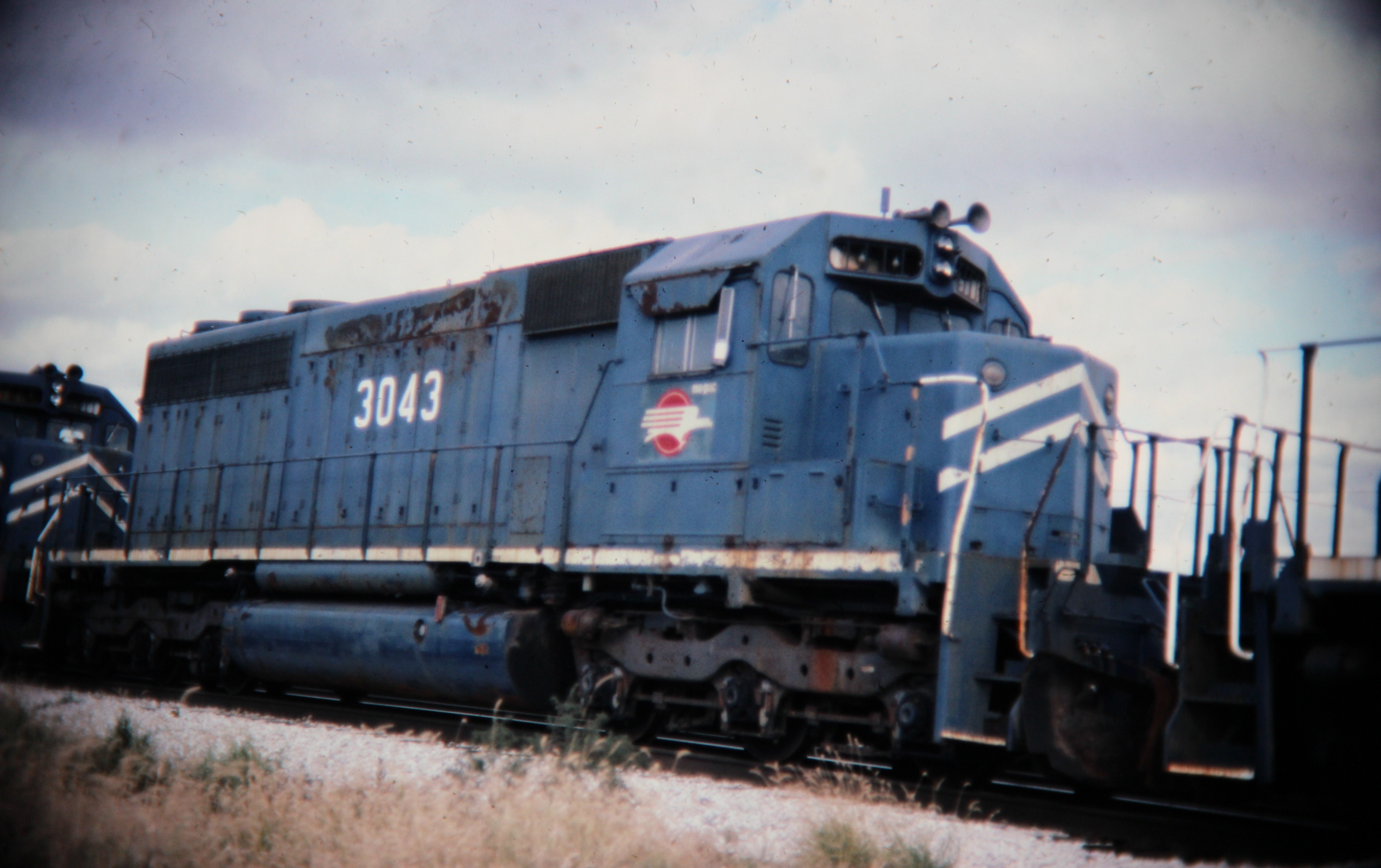 Mopac SD40 dead in tow, Savoy, IL; Western U.S. railroads, 1986; digital copy of slide. Complete indexed photo collection at WorldHistoryPics.com.