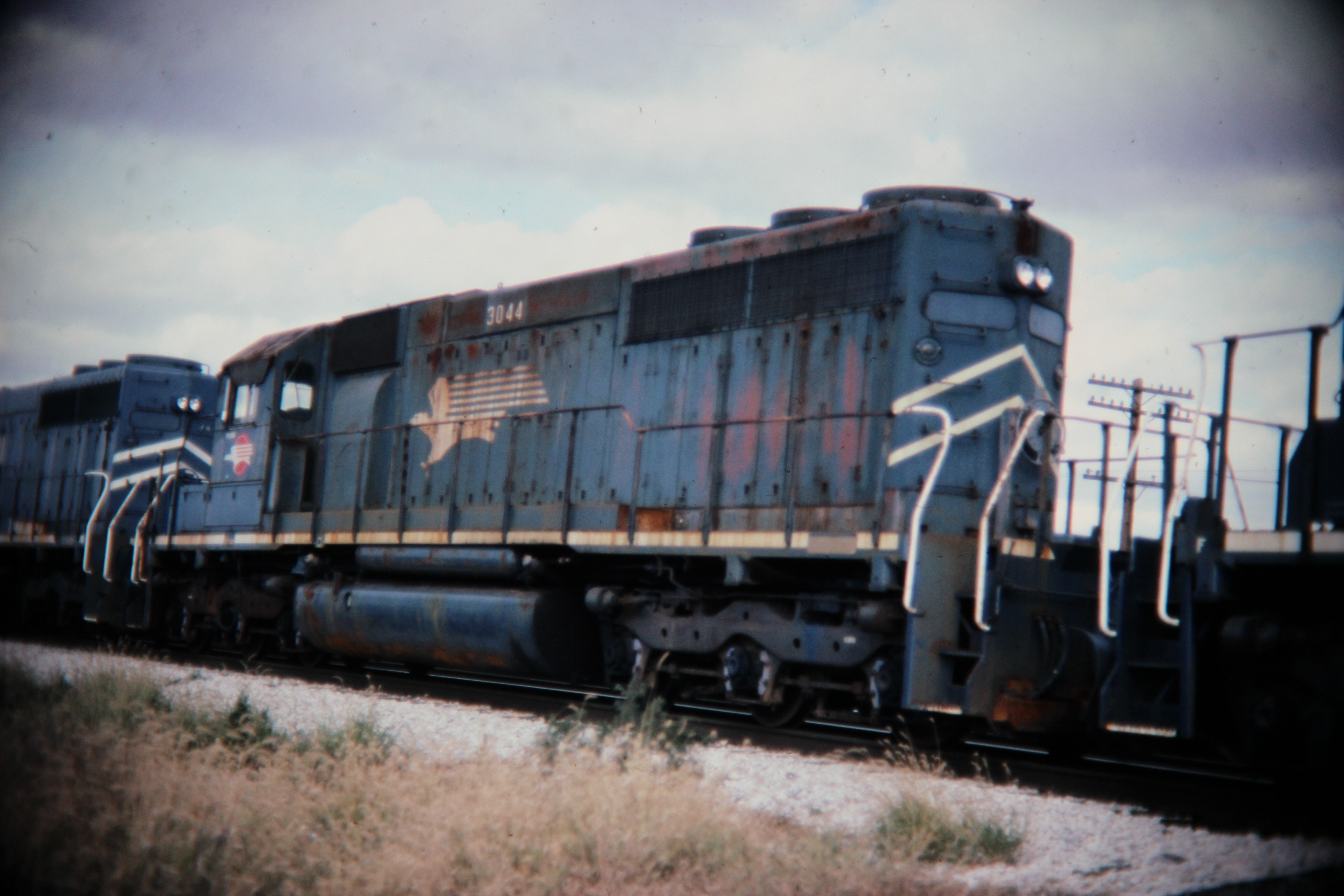 Mopac SD40 dead in tow, Savoy, IL; Western U.S. railroads, 1986; digital copy of slide. Complete indexed photo collection at WorldHistoryPics.com.