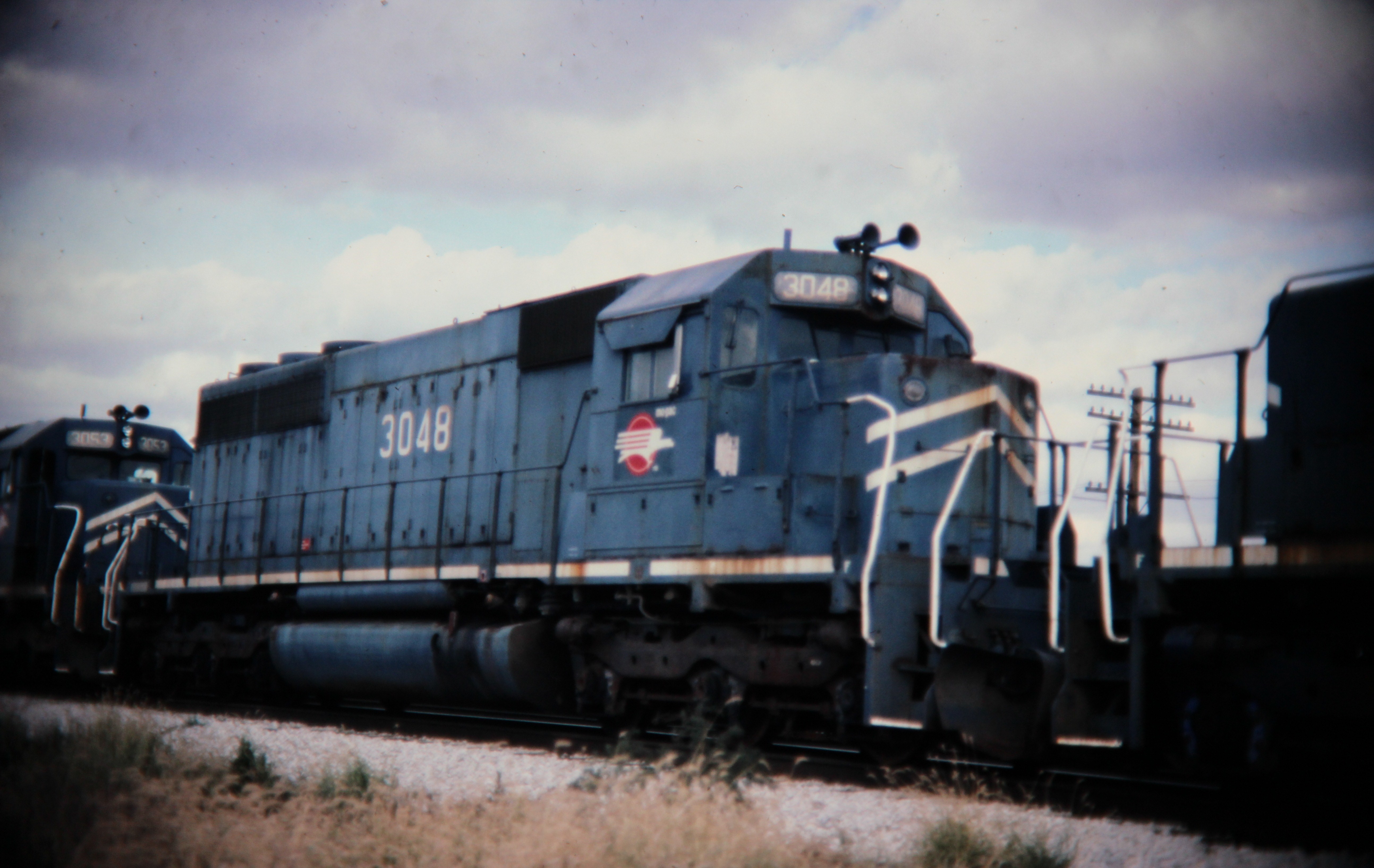 Mopac SD40 dead in tow, Savoy, IL; Western U.S. railroads, 1986; digital copy of slide. Complete indexed photo collection at WorldHistoryPics.com.