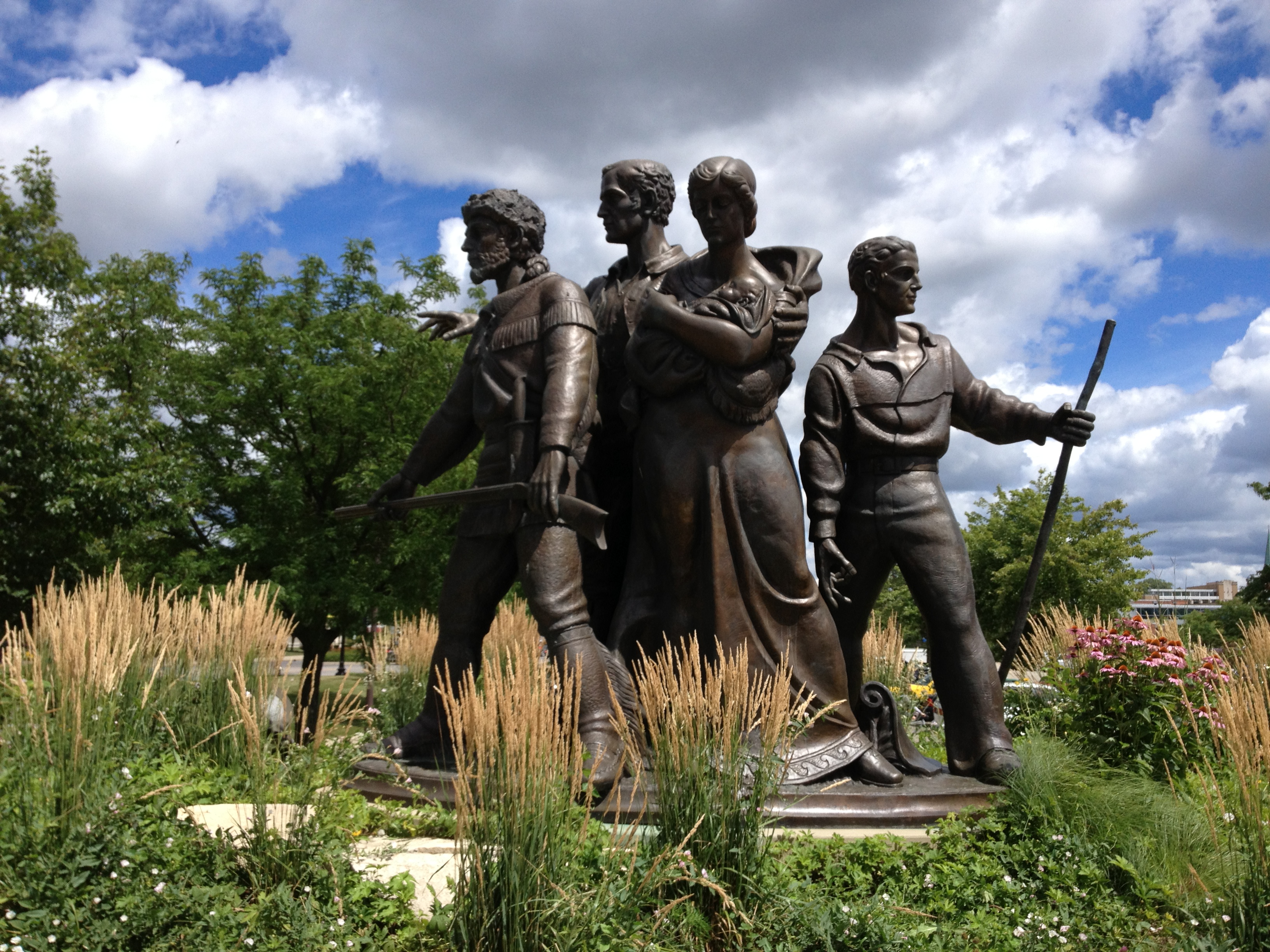 The Pioneer Family Memorial statue, designed by Trygve Rovelstad, located on the east side of the Kimball Street bridge in Elgin, Illinois, July 2013.
