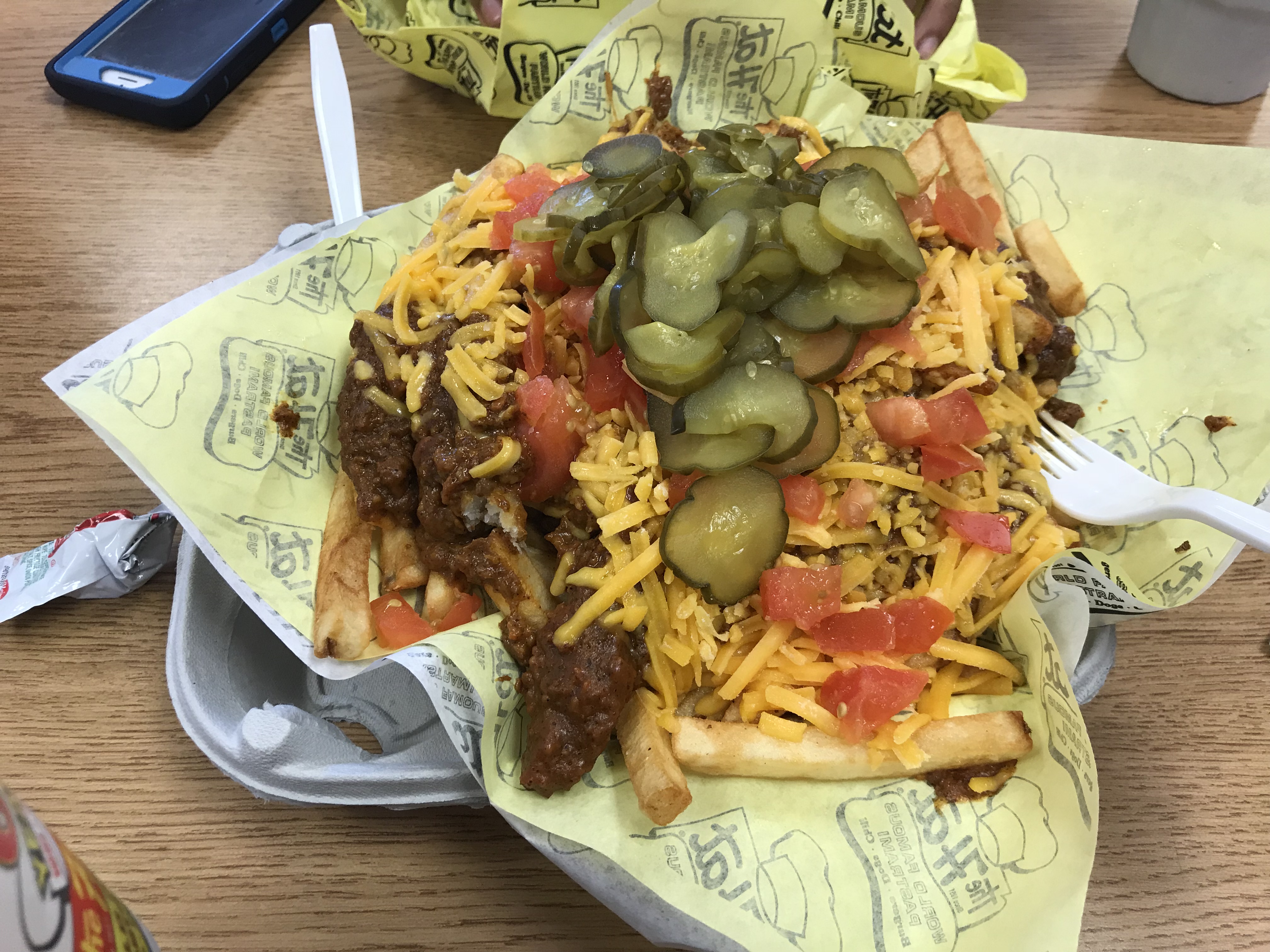 Chili cheese fries with tomato and pickles from The Hat
